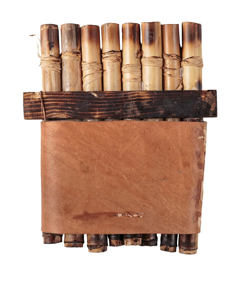 Eight cane panpipes bound together with cord, a wooden brace and a broad leather cover